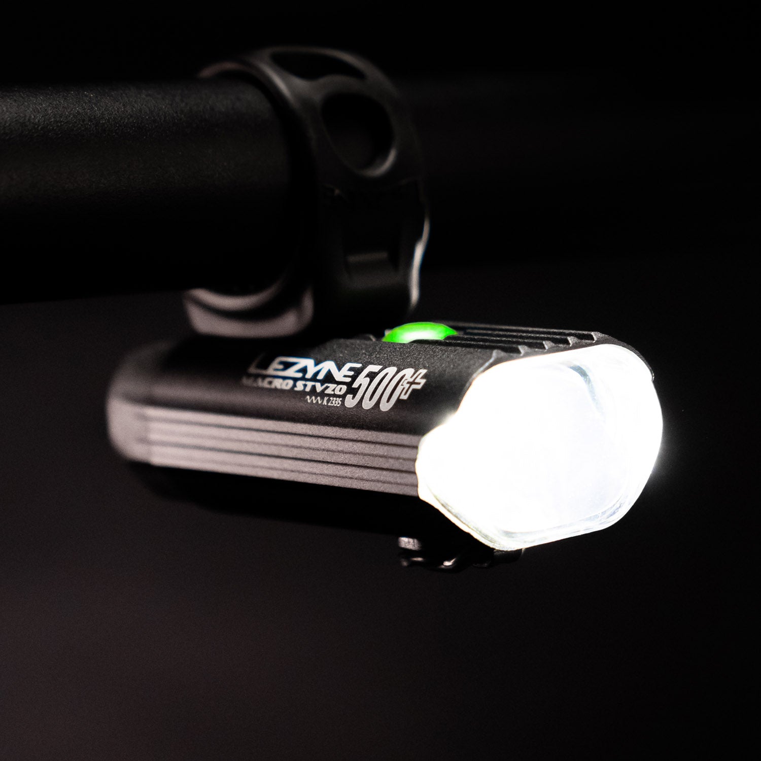 Side view of the Lezyne Macro StVZO 500+ Reverse Bike Light, with branding visible on the side and a green circular power light on top, mounted upside down on the handlebars.