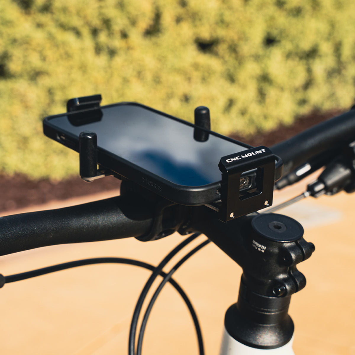 Phone mounted on bicycle with CNC Phone Mount, showing secure spring-loaded grip for rough or high-speed rides.