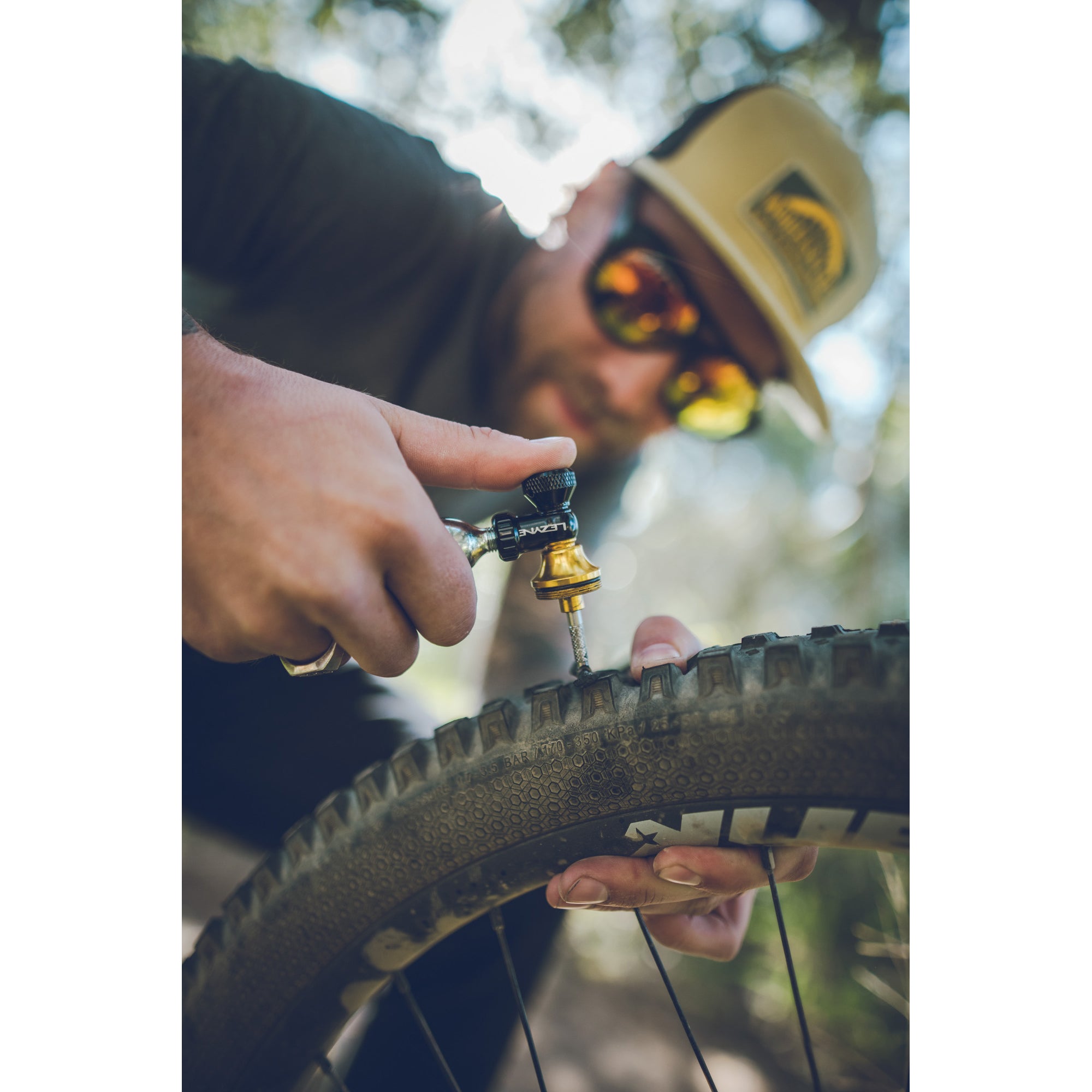 CO2 cartridge in use with Lezyne Blaster, inflating tubeless tire quickly after inserting plug into puncture.