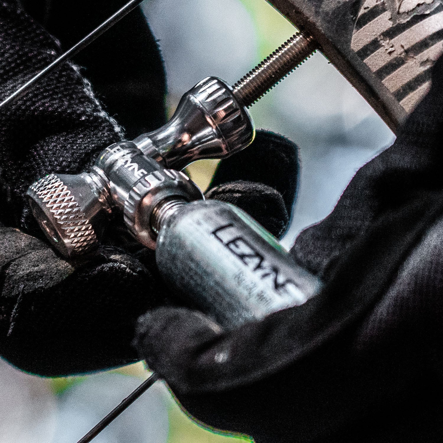 Mountain biker using silver Control Drive CO2 inflator on the trail, shown with threaded cartridge and twist valve control.
