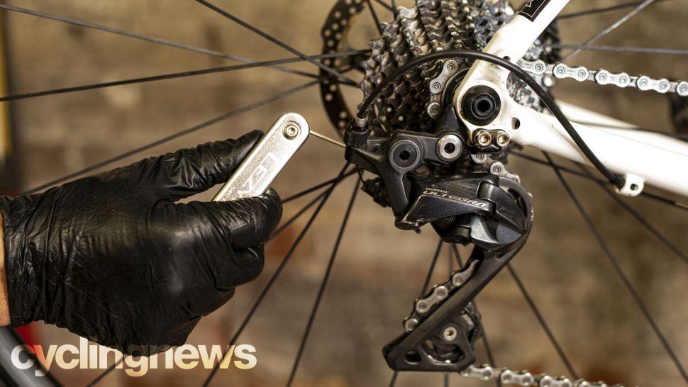 gloved hand using hex kit on bike