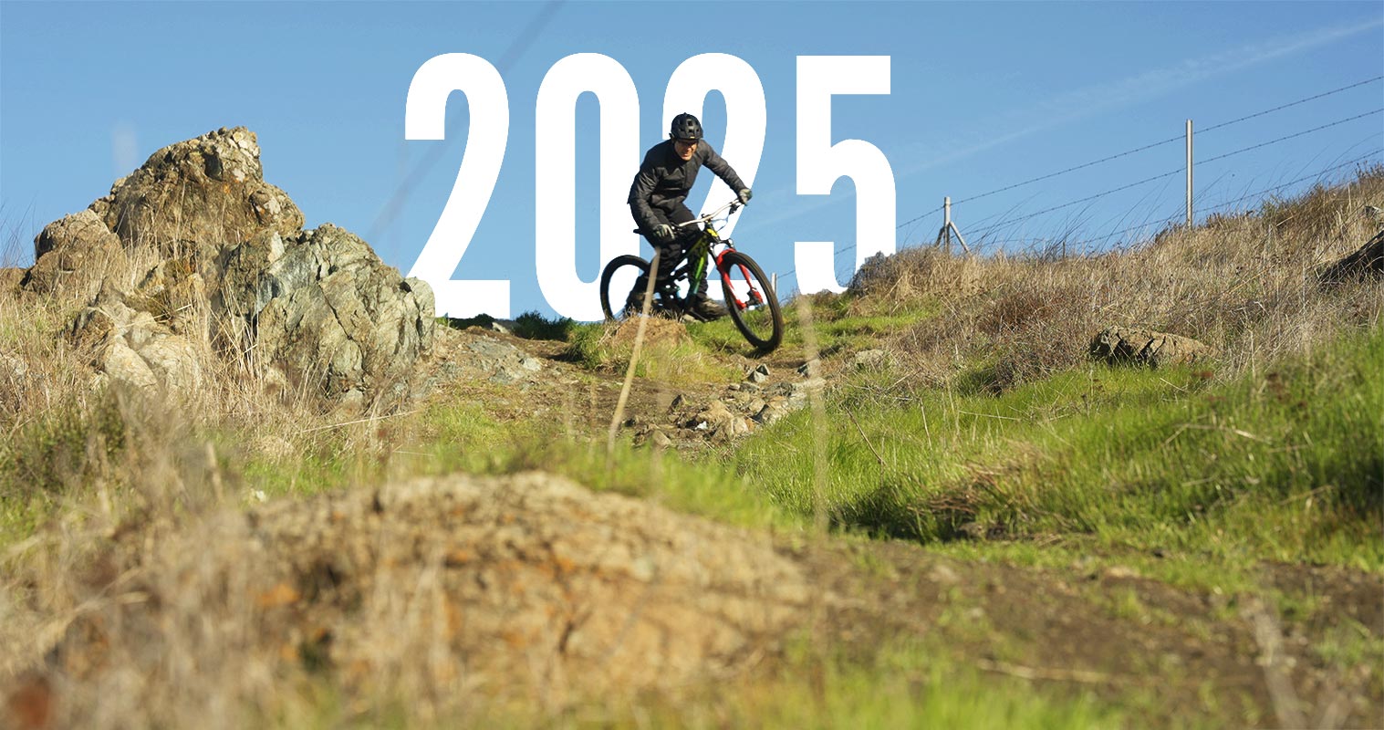 A mountain biker rides down a rugged hill, celebrating the spirit of adventure and fresh starts in the Ultimate 2025 New Year’s Cycling Guide.