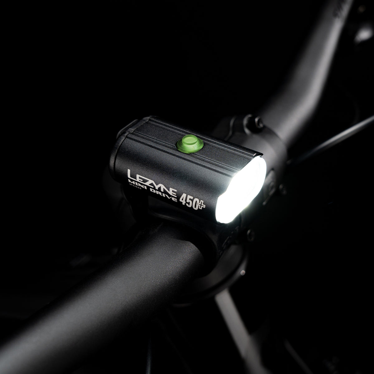 Top-view studio shot of the Lezyne Mini Drive 450+ Front with illuminated multifunction button
