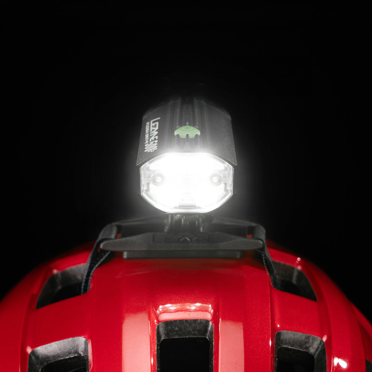 Front close-up studio shot of the Lezyne Helmet Fusion Drive 500+ with bright light beam mounted on a red helmet 