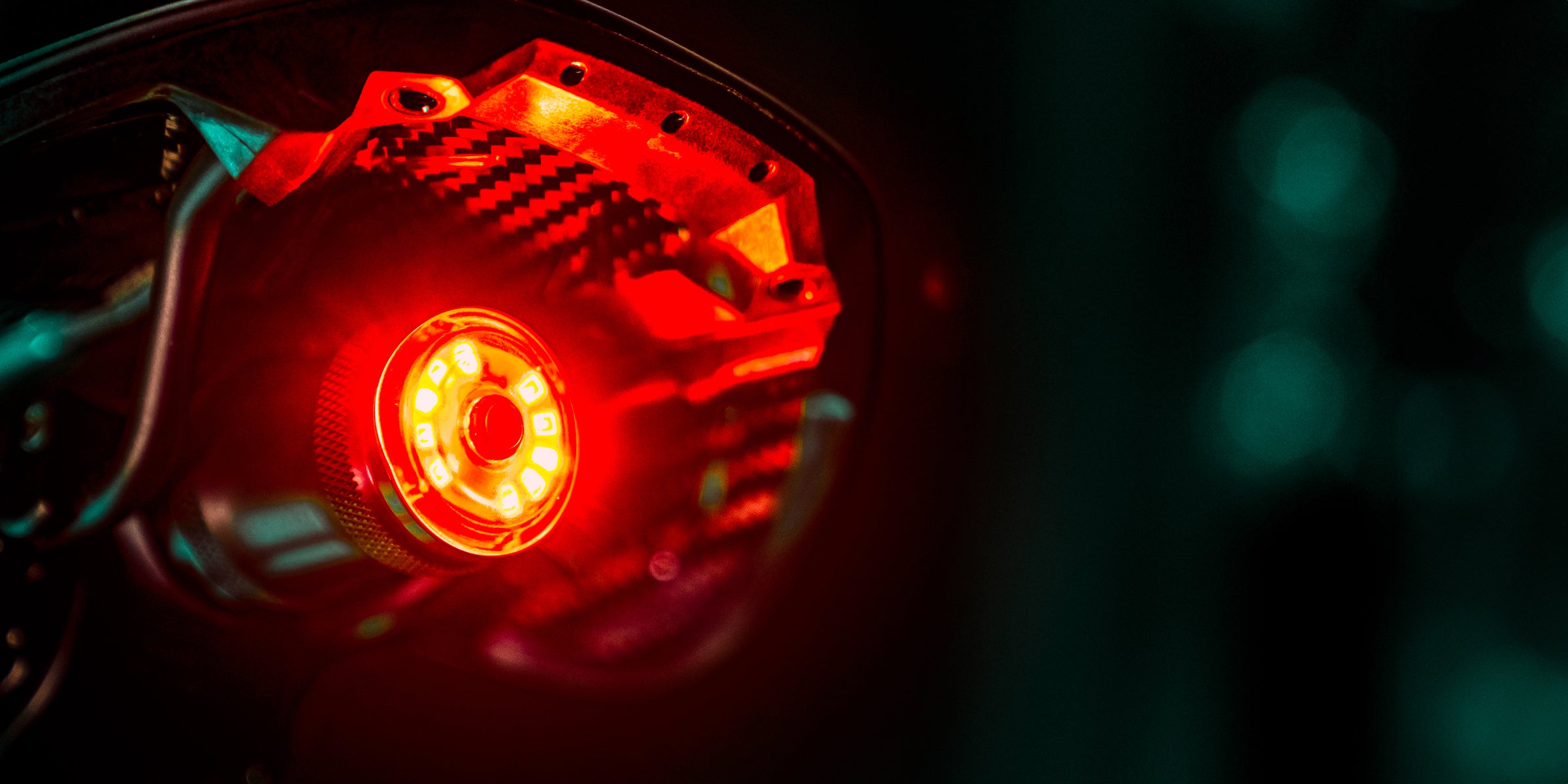 Close up of bright red light mounted to a bicycle saddle.