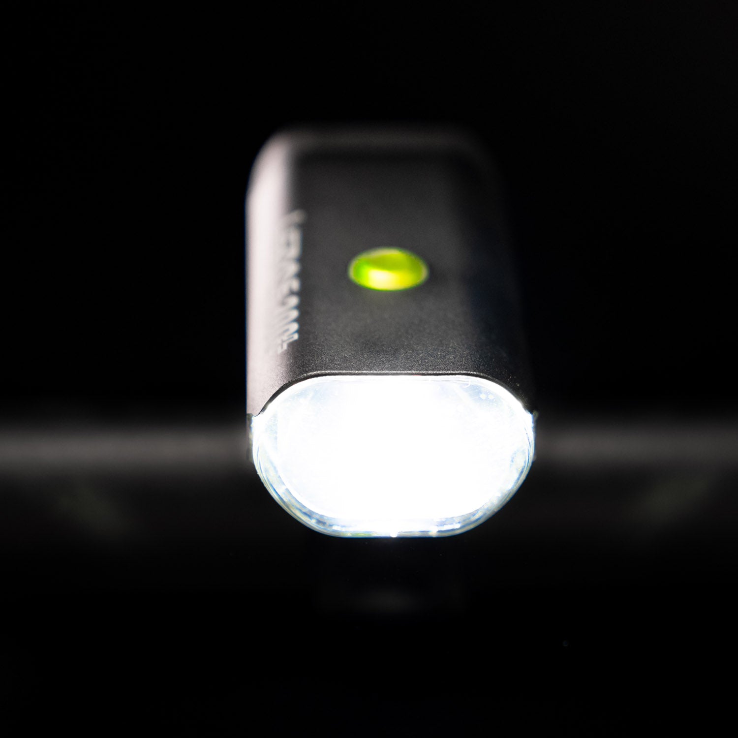 Front view of the Lezyne Micro StVZO 300+ LED bicycle light, facing the viewer with a green circular power light on top, mounted on the handlebars.