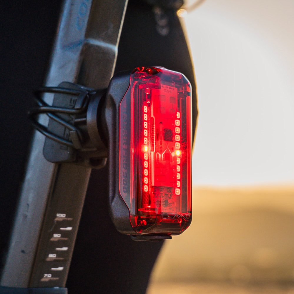 A close-up shot of a Radar Pro300 LED bicycle tail light mounted on a black frame, with a blurred outdoor background.