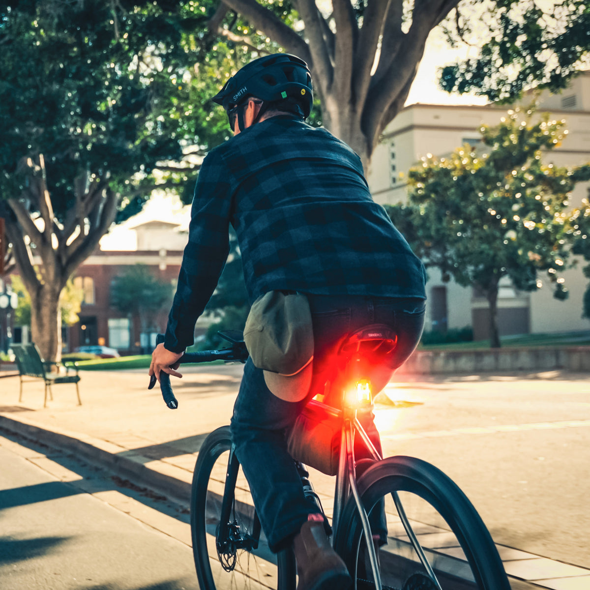Back view of commuter with bright Lezyne Radar StVZO Rear visible in daylight, enhancing rider safety and visibility.