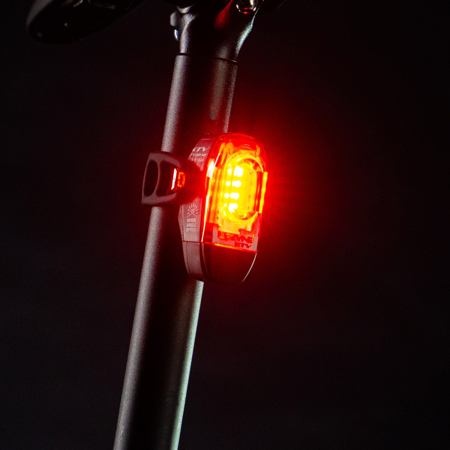 Front-side view of the Lezyne KTV Drive StVZO Rear LED bike light, emitting a bright red light, mounted on the seat post.